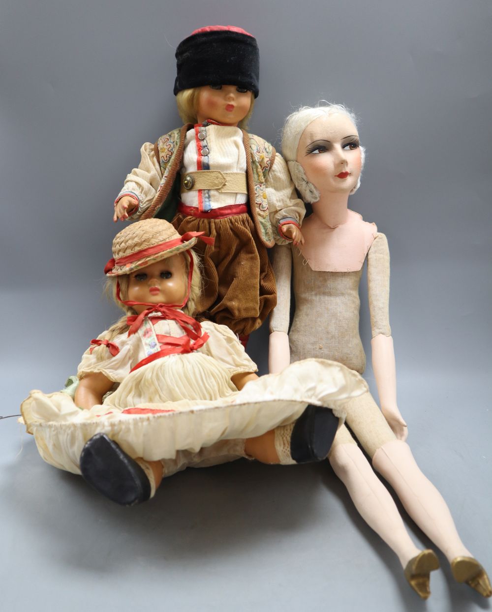 A 1920s boudoir doll, height 68cm and two costume dolls